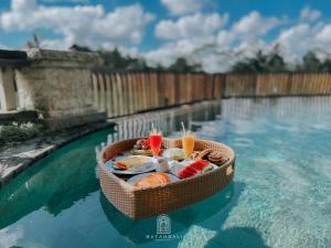 ギャニャールにあるThe Paddies Villa #deluxのプールの横の水に座った食べ物のバスケット