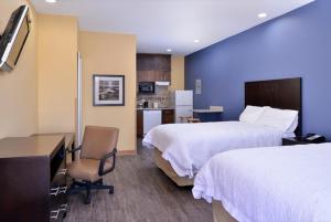 a hotel room with two beds and a desk and a kitchen at La Bonita Inn & Suites - Crane in Crane +32 photos