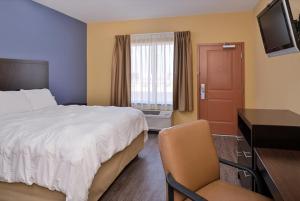 a bedroom with a bed and a desk and a television at La Bonita Inn & Suites - Crane in Crane