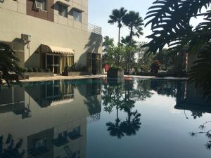 a pool of water in front of a building at Cozy 2BR at Pinewood Apartment By Travelio in Sumedang