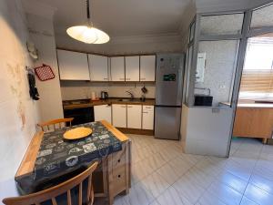 a small kitchen with a table and a refrigerator at Alquilaencanarias Tabaiba vista mar in Tabaiba