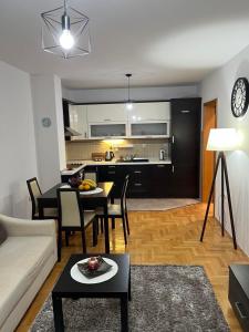 a living room with a couch and a table and a kitchen at Apartman KIKA in Banja Luka