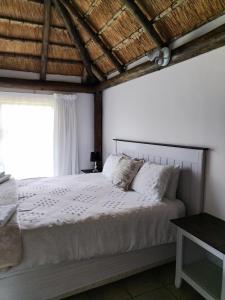 a bedroom with a white bed with a window at lrish Mist Estate in Howick