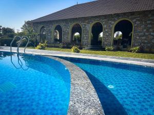 a blue swimming pool in front of a building at Jawai's Wildness Lodge in Bera