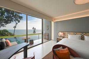 a bedroom with a bed and a view of the ocean at Rocky's Boutique Resort - Veranda Collection Samui in Lamai