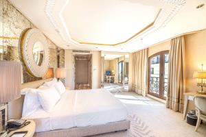 a bedroom with a bed and a desk and a room at Wyndham Grand Istanbul Kalamış Marina Hotel in Istanbul