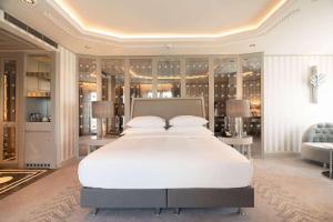 a bedroom with a large white bed and a couch at Wyndham Grand Istanbul Kalamış Marina Hotel in Istanbul