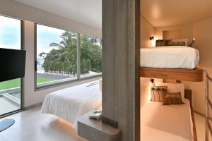 a bedroom with a bunk bed and a large window at Rocky's Boutique Resort - Veranda Collection Samui in Lamai
