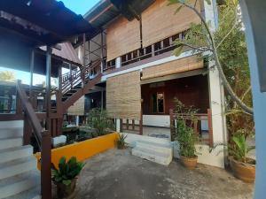 a building with stairs and plants in front of it at Sabai ça Baille Guesthouse in Pakse