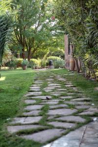 a stone path in a garden with trees and grass at La Ferme Berbere Adult only in Marrakech +133 photos