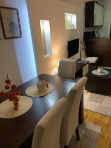 a living room with a wooden table and chairs at Beli Apartman u Zlatiborskim konacima Bele vode bb in Zlatibor +23 photos