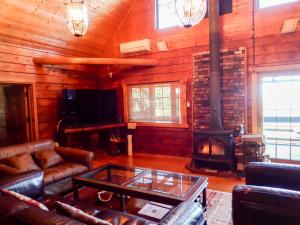 a living room with a fireplace and a stove at HIDEAWAYMountainLodge in Itoshima