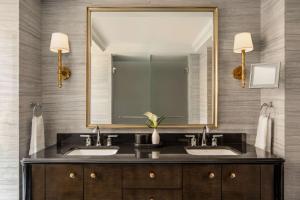 a bathroom with two sinks and a large mirror at Waldorf Astoria New York in New York +51 photos