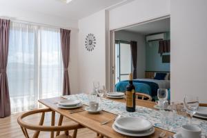 a dining room with a table with a bottle of wine at Pool Villa The Sweet Kouri Island in Nakijin