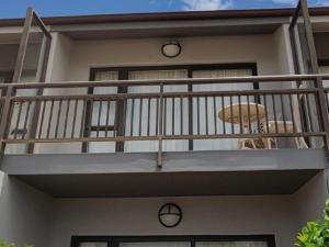 a house with a balcony with a umbrella on it at Sunset Lodge in St. Helena Bay +8 photos