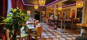 a restaurant with a bar with a potted plant at Hotel Restaurant Oliva in Nordwalde