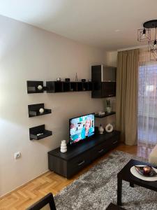 a living room with a flat screen tv on a wall at Apartman KIKA in Banja Luka
