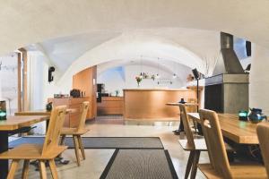 una sala da pranzo con tavoli in legno e una cucina di HOTEL BLAUE ROSE -digital check in- a Feldkirch