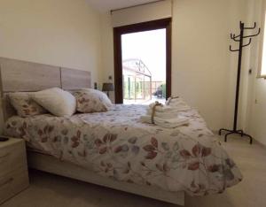 a bedroom with a bed with a floral bedspread and a window at La Costana De Barbadillo in Barbadillo del Mercado +12 photos