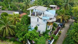 an overhead view of a house with palm trees at Habibi Hostel & Restaurant in Unawatuna