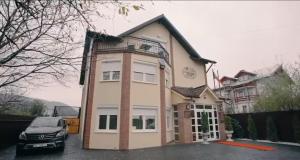 a house with a car parked in front of it at Casa Rosa in Piatra Neamţ
