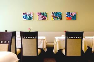 a restaurant with tables and chairs and paintings on the wall at Hotel am Jakobsmarkt in Nuremberg