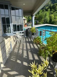 a patio with a table and chairs on a house at Villa Nola in Port-of-Spain