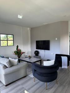 a living room with a couch and a table and chairs at Villa Nola in Port-of-Spain