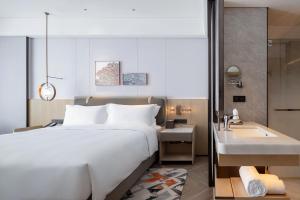 a bedroom with a large bed and a sink at Wyndham Grand Plaza Royale Lugu Changsha in Changsha +25 photos