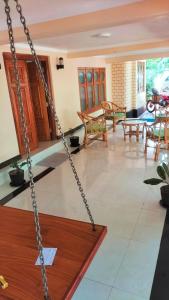 a swing in a living room with a table and chairs at Leela Resort in Karainagar