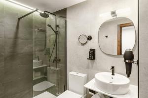 a bathroom with a shower and a sink and a mirror at Limehome Jerez de la Frontera Marqués de Casa-Domecq in Jerez de la Frontera +42 photos