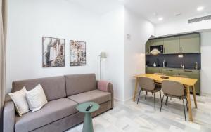 a living room with a couch and a table at Limehome Jerez de la Frontera Marqués de Casa-Domecq in Jerez de la Frontera