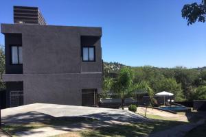 a house with a yard with a swimming pool at Quadro Departamentos in Villa Carlos Paz