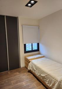 a bedroom with two beds and a window at Quadro Departamentos in Villa Carlos Paz