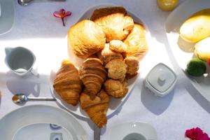 a plate of croissants and breads on a table at Oasis du Lagon - Villa Hugo in Saint-Gilles les Bains