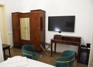 una stanza con una tv, un tavolo e delle sedie di LN B&B CATANIA a Catania