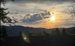 a sunset over the mountains with the sun setting at Na samotě u lesa in Vsetín
