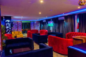 una camera con sedie rosse e blu e una TV di House10 luxury hotel and suites a Lagos