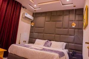 una camera con un grande letto con una grande testiera imbottita di House10 luxury hotel and suites a Lagos