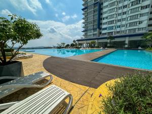 a swimming pool next to a large building at Palmyra Stylish New Condo in Kajang