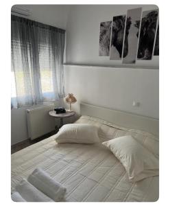 a bedroom with a large white bed with a window at Vila Veta in Galatas