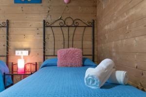 ein Schlafzimmer mit einem blauen Bett an einer Holzwand in der Unterkunft El Refugio de Conil Ideal Familias in Conil de la Frontera + 23 Fotos