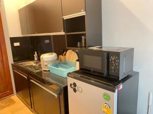 a kitchen with a microwave on top of a refrigerator at Bluda Poolvilla B in Hat Yai