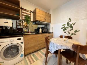 eine Küche mit einer Waschmaschine und einem Tisch mit Stühlen in der Unterkunft VitaminSEA7 Forest View 6PAX Studio Netflx B-3A-3A in Kuantan