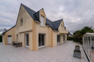 a large house with a patio in front of it at Villa - Piscine chauffée, jacuzzi in Plouharnel