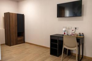 a room with a desk and a television on the wall at Locanda Borgovecchio in Manerbio