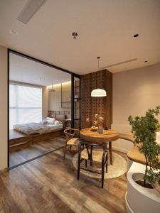 a bedroom with a bed and a table in a room at Skylux homestay Ecopark Hung Yen - Swanlake Onsen in HÆ°ng YÃªn