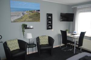 a waiting room with a desk and chairs and a table at Effe-Zoutelande in Zoutelande +38 photos