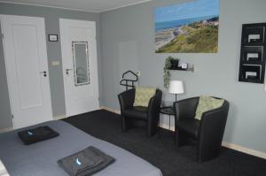 a room with two chairs and a bed and a table at Effe-Zoutelande in Zoutelande