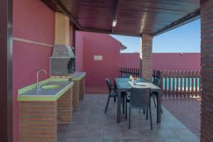 a patio with a table and chairs and a stove at Bungalow Mis Niñas 2 in Conil de la Frontera